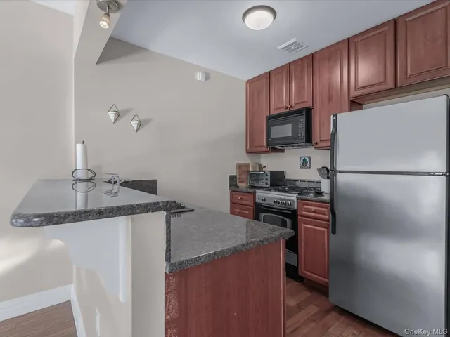 a kitchen with a granite countertop sink and refrigerator