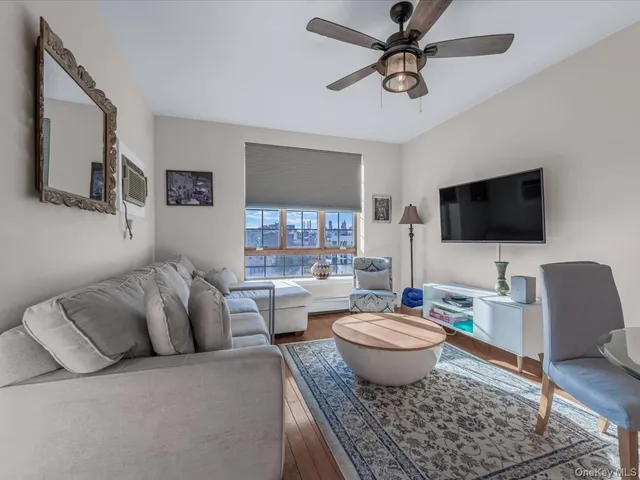 a living room with furniture a ceiling fan and a window