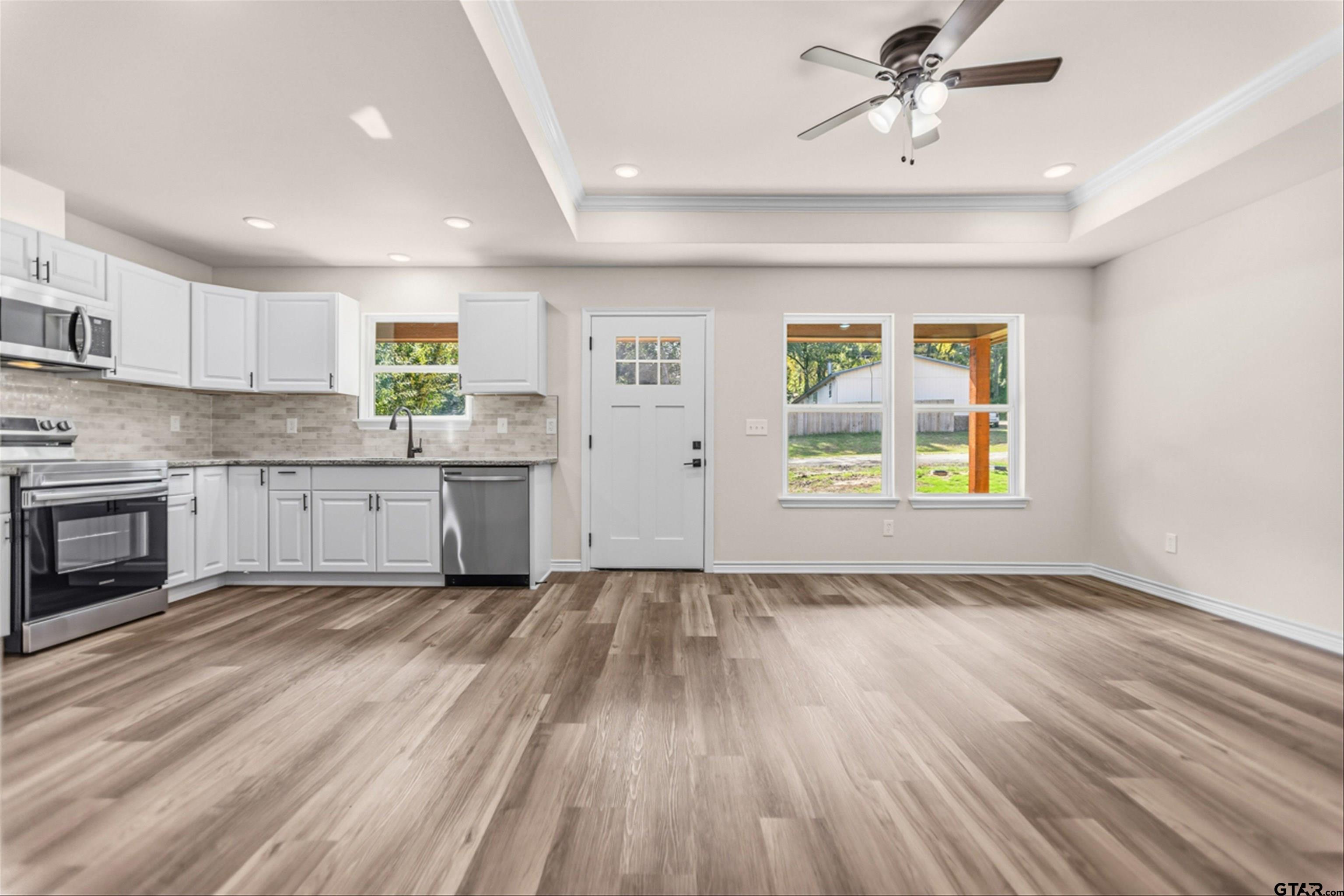 a view of a kitchen with a sink cabinets wooden floor and a window
