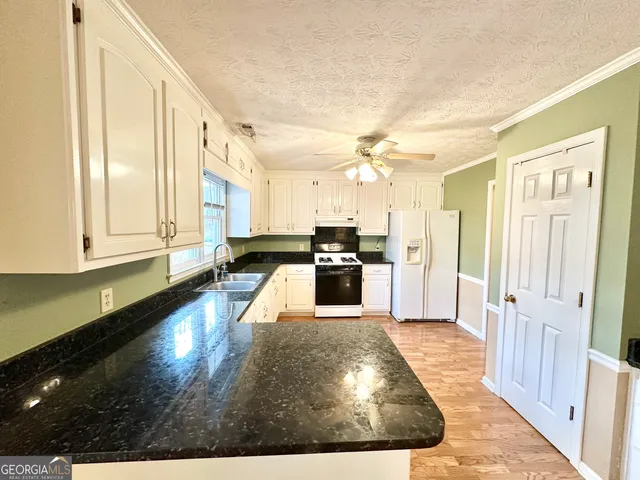 a kitchen with stainless steel appliances granite countertop a sink and a stove