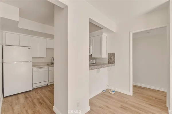 a kitchen with white cabinets and white appliances