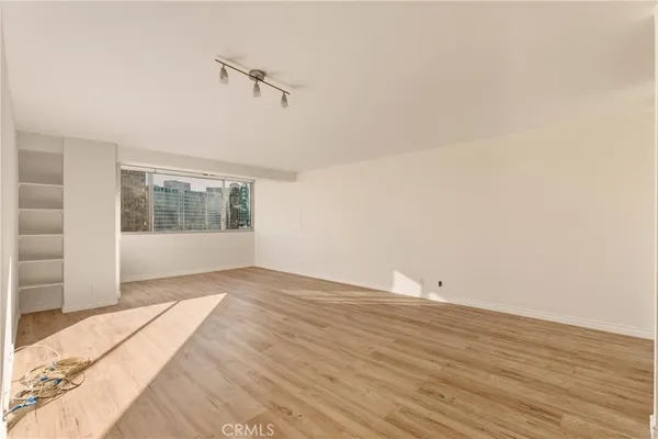 a view of a livingroom with wooden floor and a large window