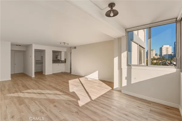 a view of room with wooden floor and kitchen