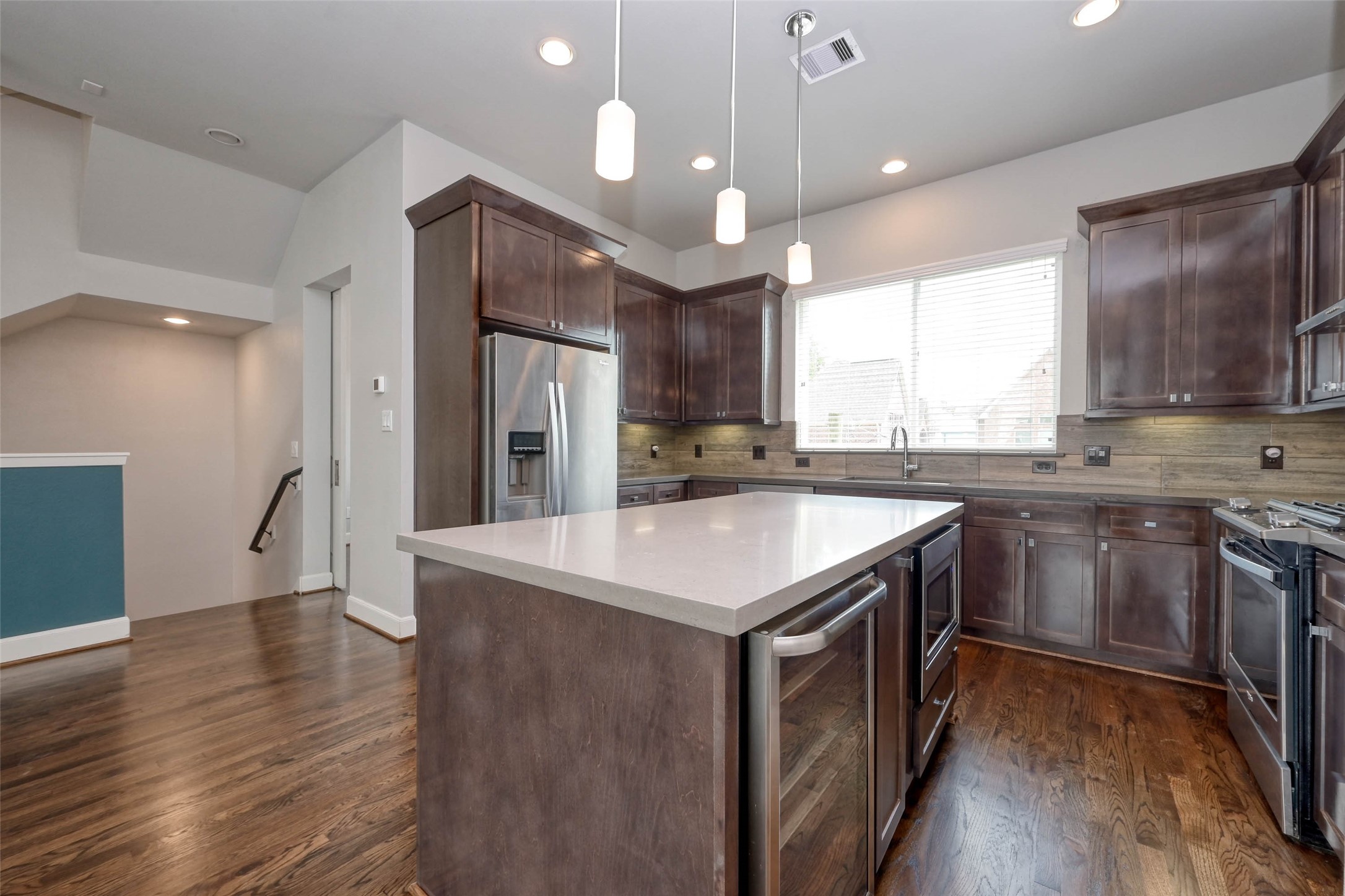 951 West 17th Street Houston, TX 77008 - Photo 12 of 30 The Quartz-Topped Island with Overhead Pendant Lighting Houses the Low-Mounted Microwave and Wine Cooler.