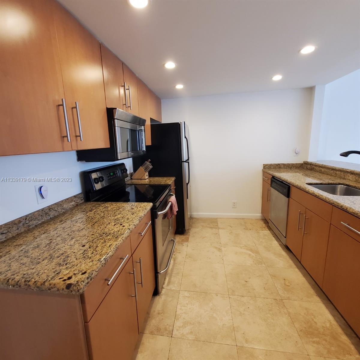 245 18th Street, Unit 403 Miami Beach, FL 33139 - Photo 9 of 30 a kitchen that has a sink and a stove in it
