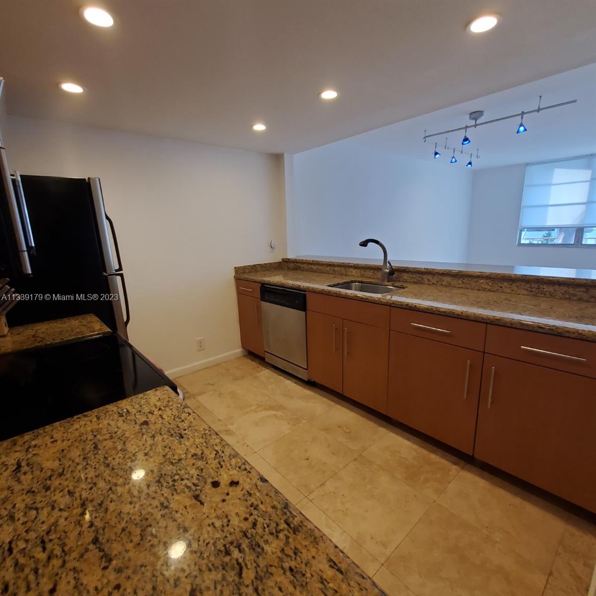 245 18th Street, Unit 403 Miami Beach, FL 33139 - Photo 10 of 30 a kitchen with stainless steel appliances granite countertop a sink and cabinets