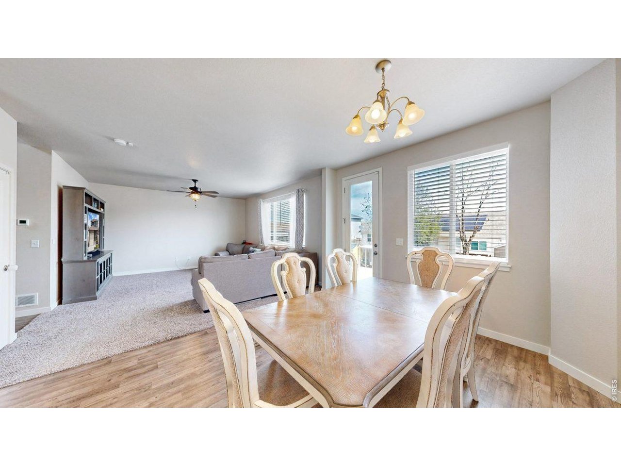 620 Cimarron Trail Ault, CO 80610 - Photo 13 of 37 a dining room with wooden floor a chandelier a wooden table and chairs