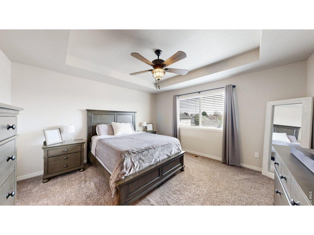 620 Cimarron Trail Ault, CO 80610 - Photo 15 of 37 a bedroom with a bed and a chandelier