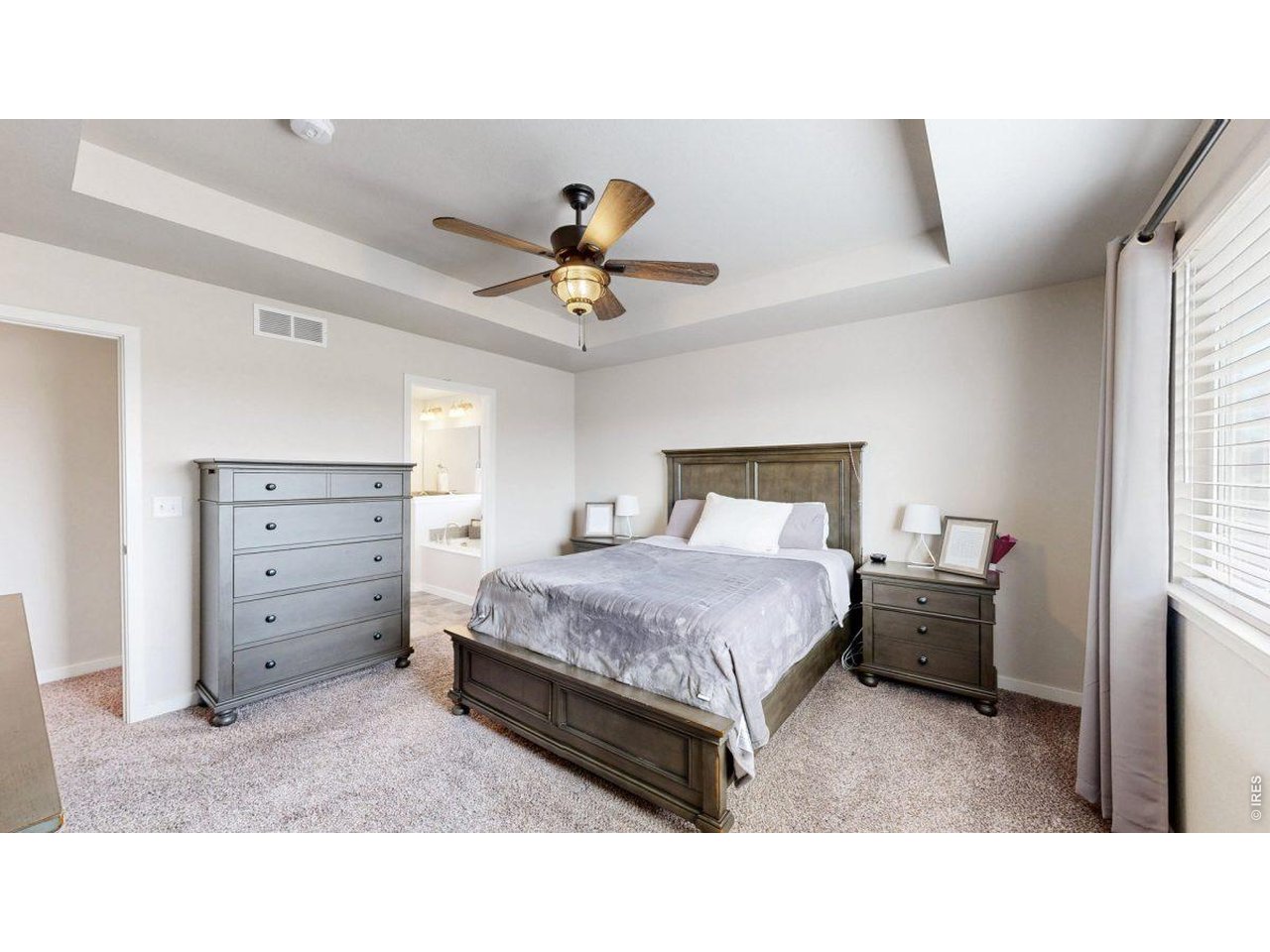 620 Cimarron Trail Ault, CO 80610 - Photo 16 of 37 a bedroom with a bed and a chandelier