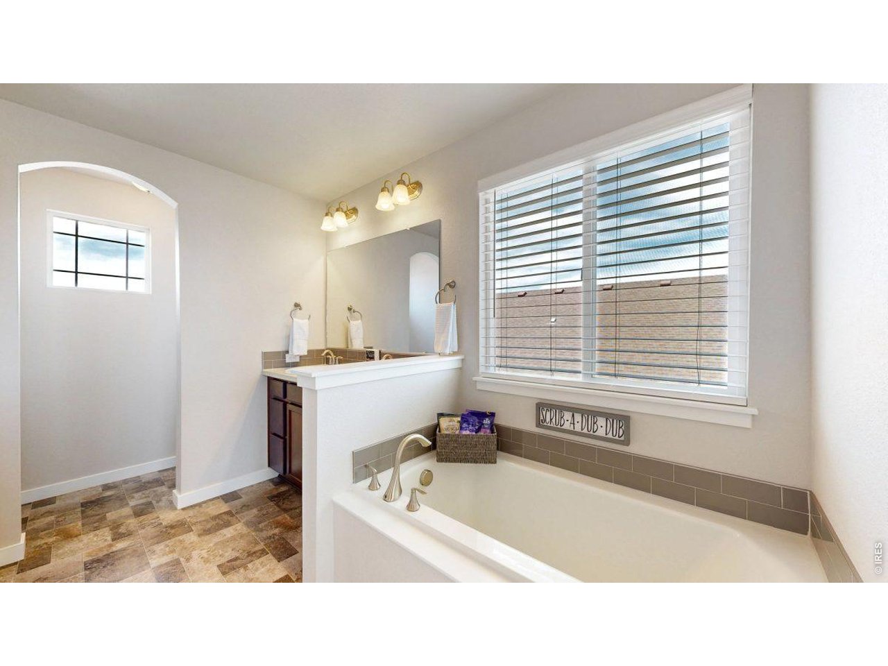 620 Cimarron Trail Ault, CO 80610 - Photo 19 of 37 a bathroom with a tub sink and a window