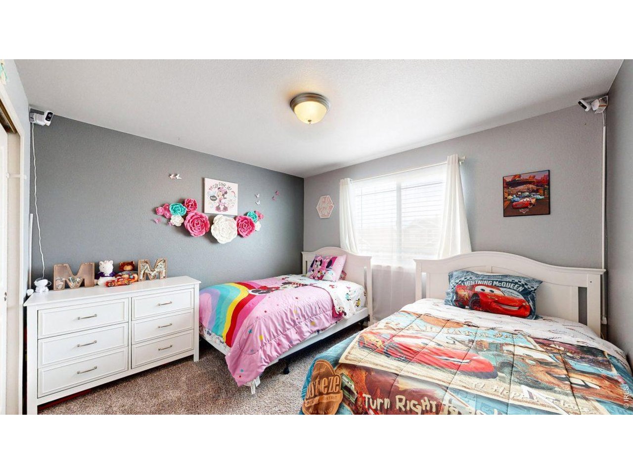 620 Cimarron Trail Ault, CO 80610 - Photo 21 of 37 a bedroom with two beds and a chandelier