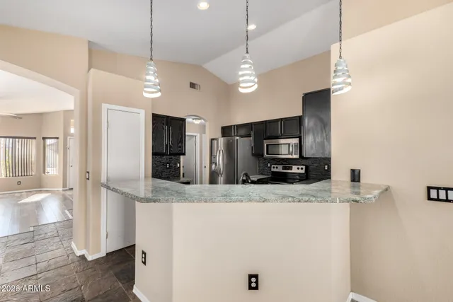 a large kitchen with a large counter top appliances and cabinets