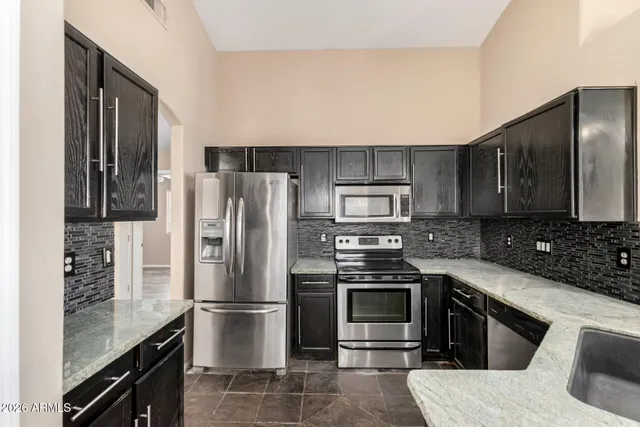 a kitchen with stainless steel appliances a refrigerator stove and sink