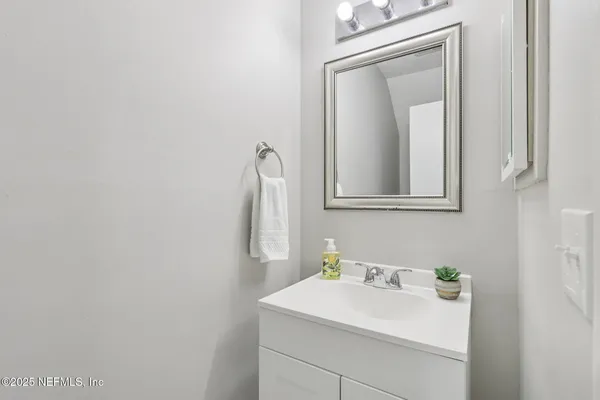 an empty room with wooden floor chandelier fan and windows