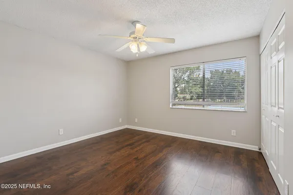 a view of an empty room with wooden floor