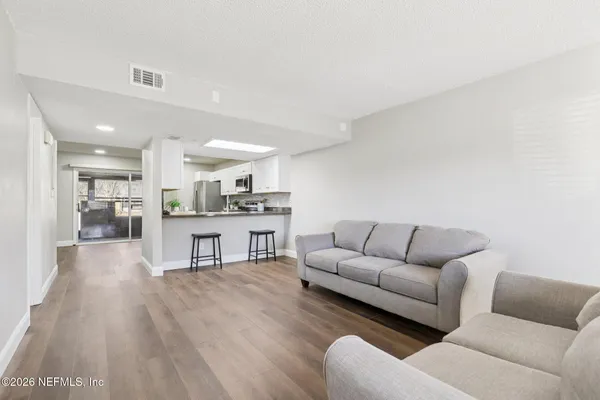 a living room with furniture and view of kitchen