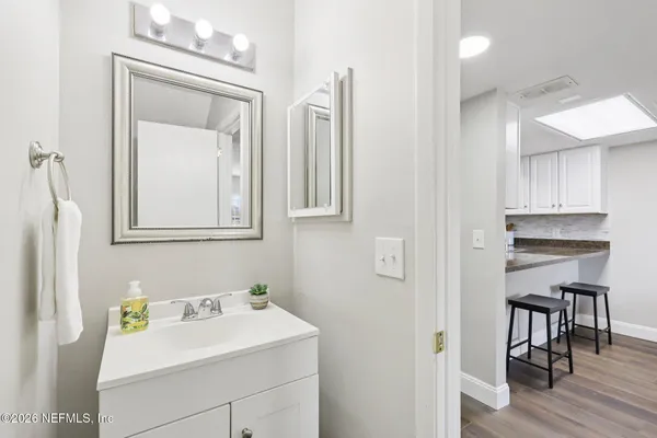 an empty room with wooden floor chandelier fan and windows