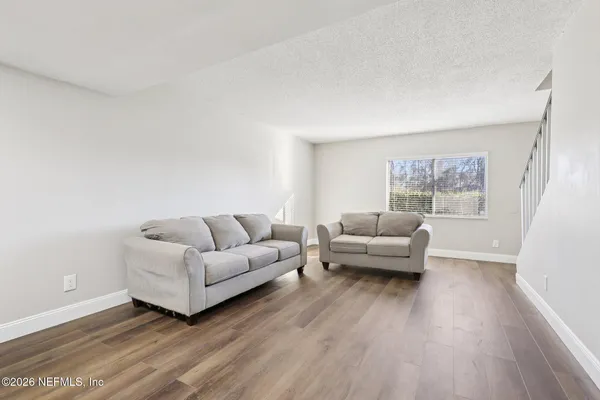 a living room with furniture and a hard wood floor