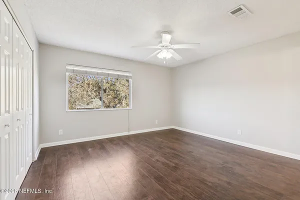 a view of an empty room with wooden floor