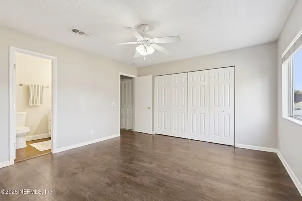 a bathroom with a granite countertop sink mirror vanity and toilet