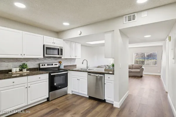 a kitchen with granite countertop a sink and cabinets