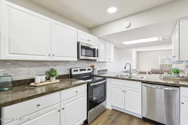 a kitchen with sink a microwave and cabinets