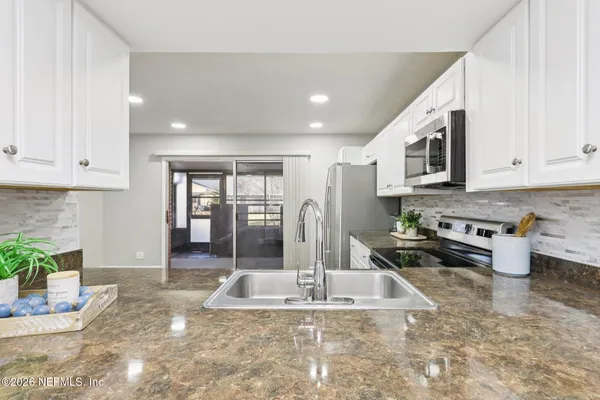 a kitchen with stainless steel appliances granite countertop a sink stove and cabinets