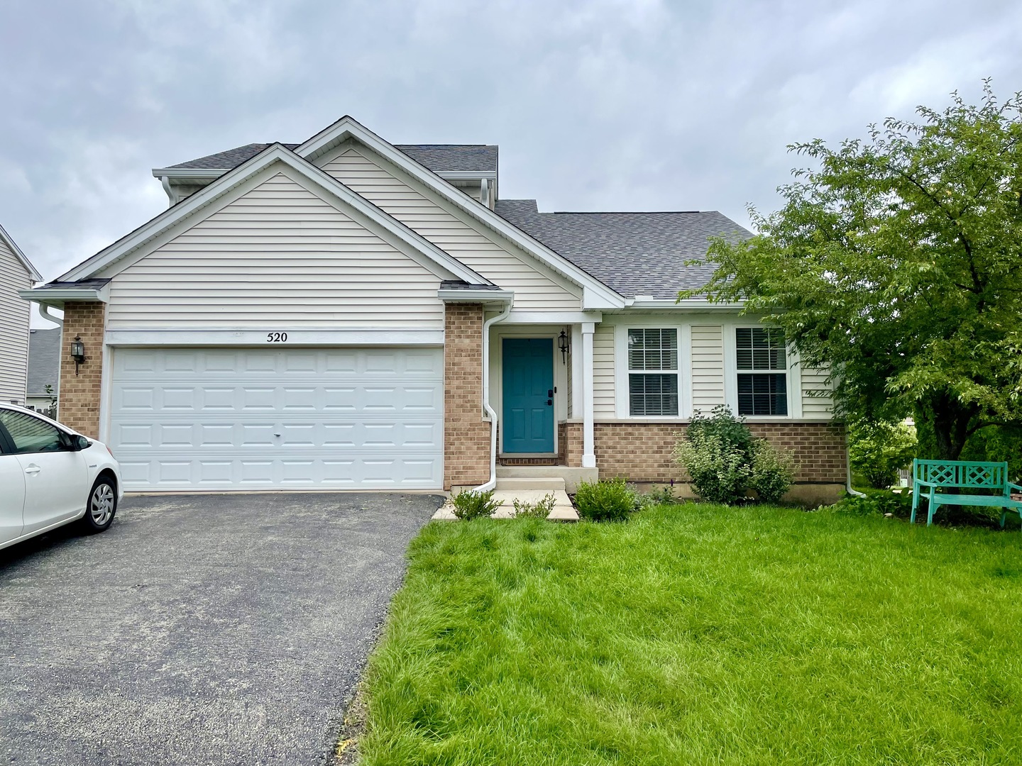 a view of a house with a yard and lawn chairs with a fire pit