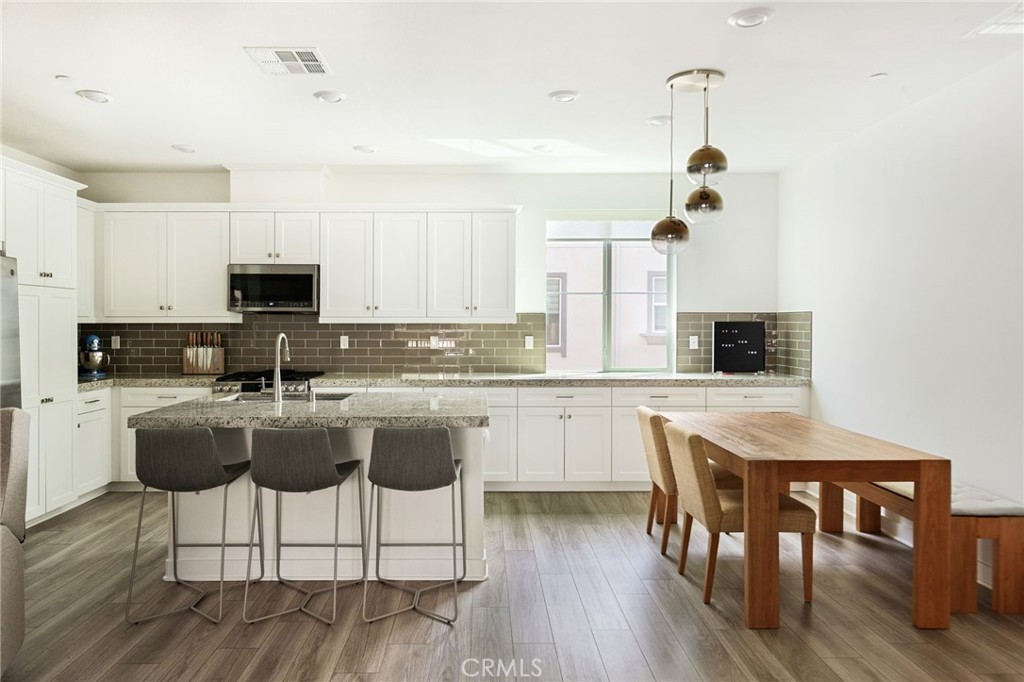 1507 St Simon Circle, Unit E Alhambra, CA 91803 - Photo 1 of 1 a large kitchen with kitchen island a dining table and chairs