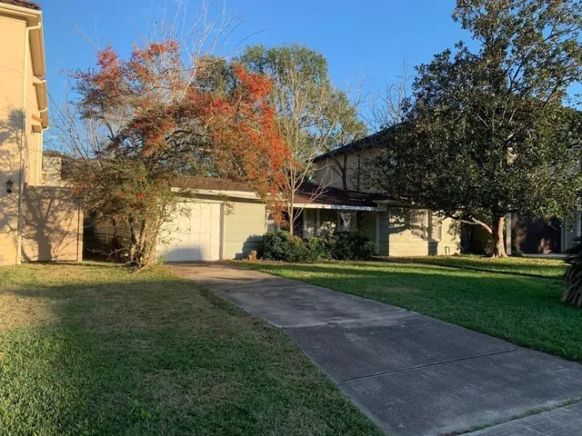 a front view of a house with a yard and trees