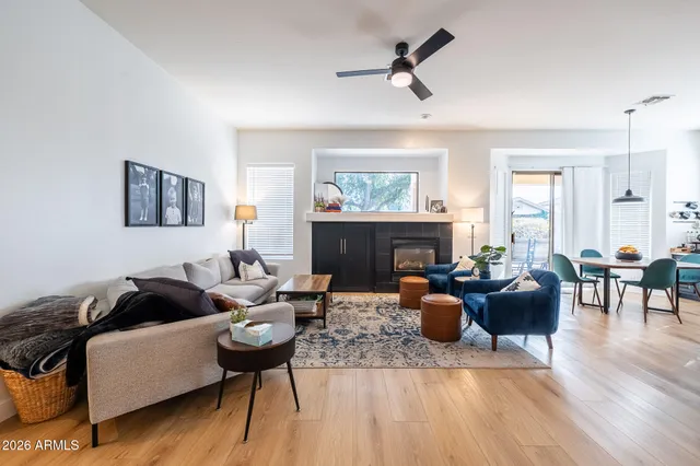 a view of a dining room and livingroom with furniture wooden floor a rug a potted plant and a chandelier