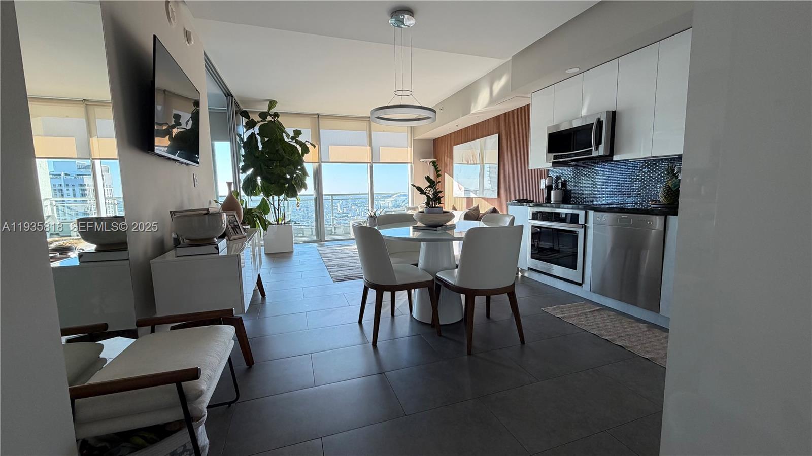 92 Southwest 3rd Street, Unit 3607 Miami, FL 33130 - Photo 3 of 33 a kitchen with a table chairs refrigerator and cabinets