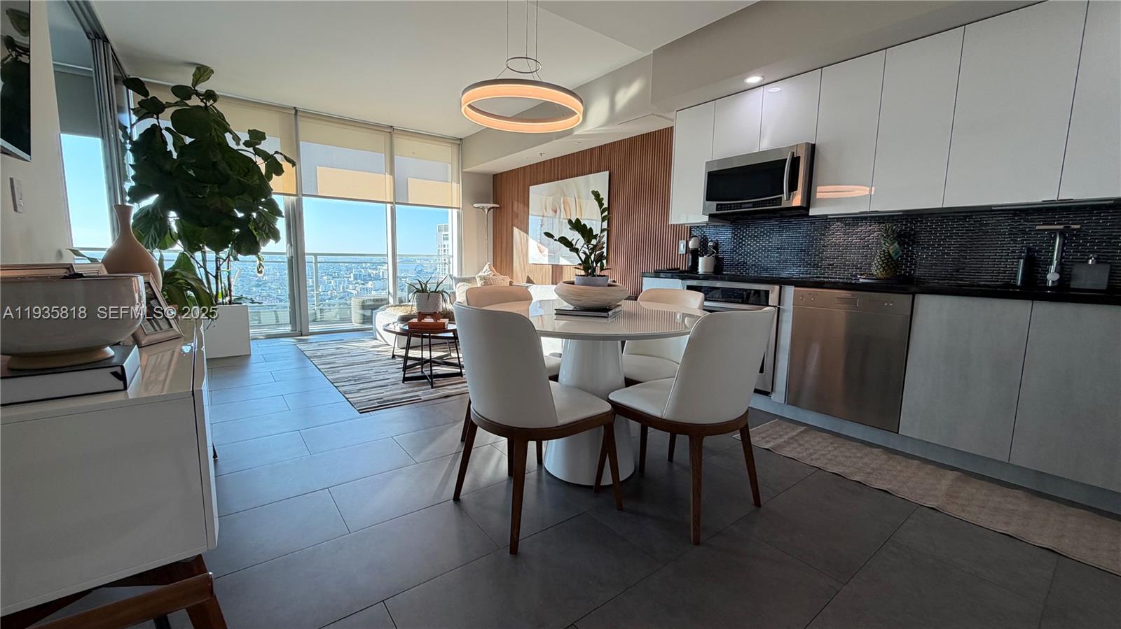 92 Southwest 3rd Street, Unit 3607 Miami, FL 33130 - Photo 4 of 33 a kitchen with stainless steel appliances a dining table chairs microwave and sink