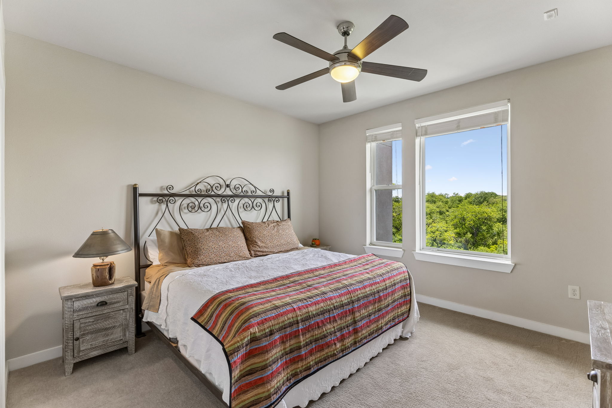 1900 Barton Springs Road, Unit 5032 Austin, TX 78704 - Photo 11 of 40 Bedroom featuring two large windows, a ceiling fan with integrated lighting, and neutral wall paint