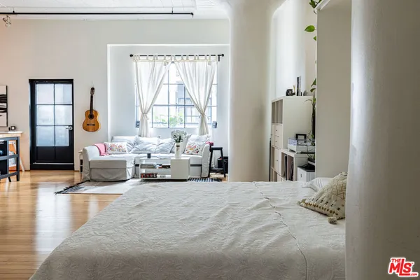 a bedroom with a bed and wooden floor