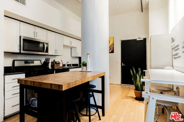 a kitchen with stainless steel appliances a stove refrigerator sink and microwave