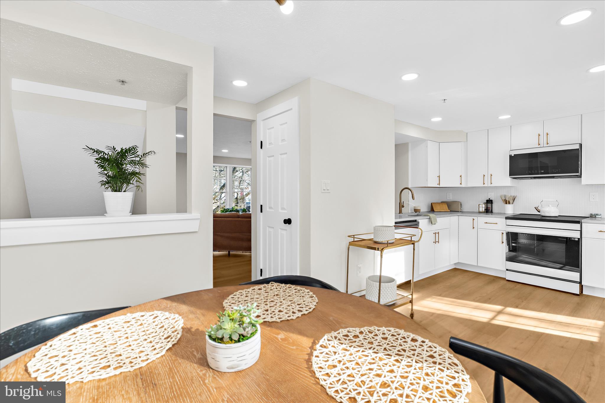 1530 Falstone Lane Crofton, MD 21114 - Photo 16 of 53 a kitchen with stainless steel appliances kitchen island granite countertop a stove a refrigerator and a dining table with wooden floor