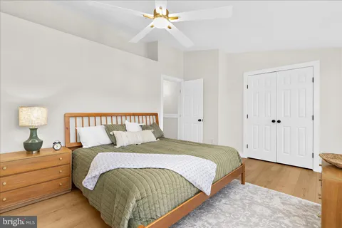 a spacious bedroom with a bed and wooden floor