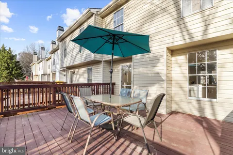 a view of a roof deck with table and chairs under an umbrella