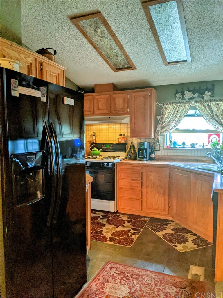 29043 Paradise Road Val Verde, CA 91384 - Photo 10 of 23 a kitchen with stainless steel appliances granite countertop a stove a sink and a refrigerator