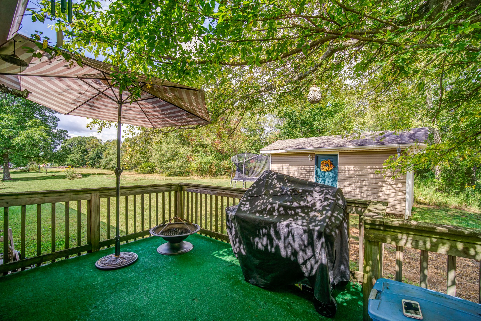 5407 Marion Road Cunningham, TN 37052 - Photo 31 of 35 a view of a deck with a table and chairs under an umbrella