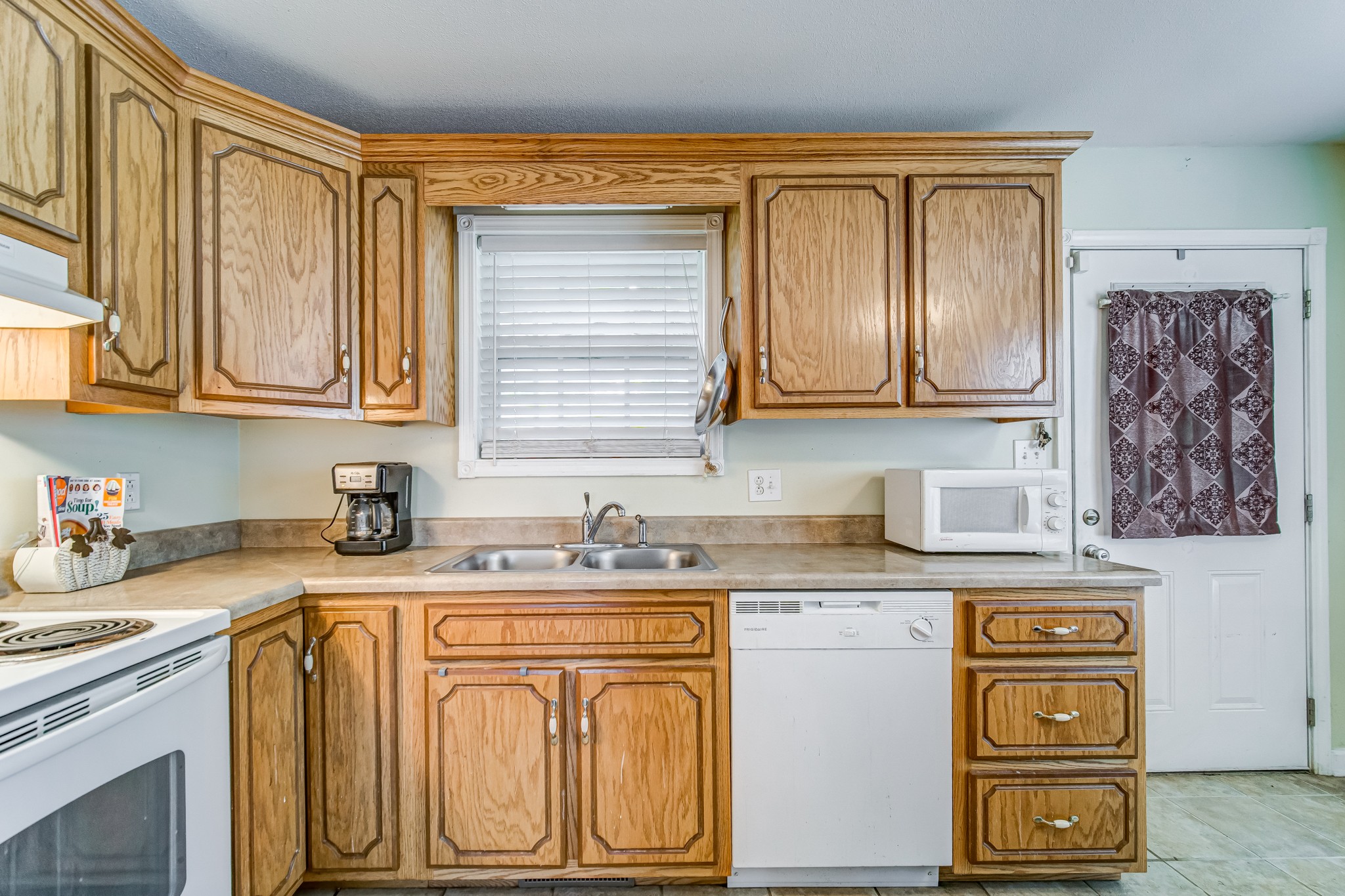5407 Marion Road Cunningham, TN 37052 - Photo 7 of 35 a kitchen with stainless steel appliances granite countertop a sink a stove cabinets and a refrigerator