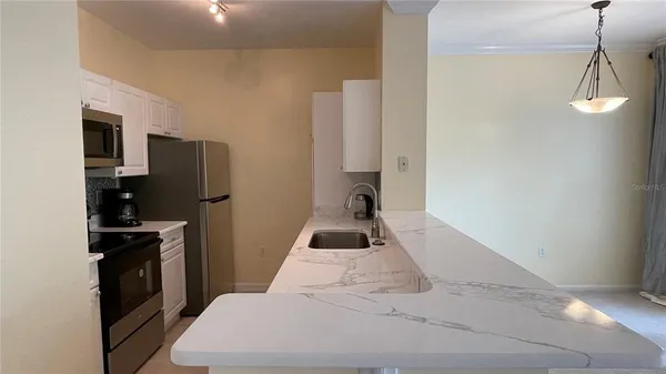 a bedroom with a bed and a kitchen