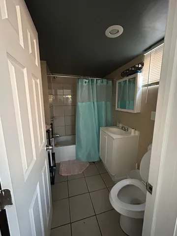 a living room with lots of furniture a chandelier and a dining table