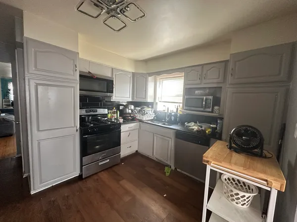 a kitchen with a stove a refrigerator and a stove top oven