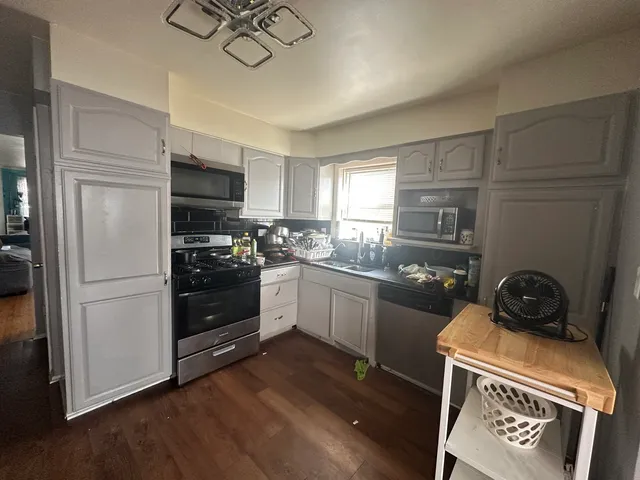 a kitchen with a stove a refrigerator and a stove top oven