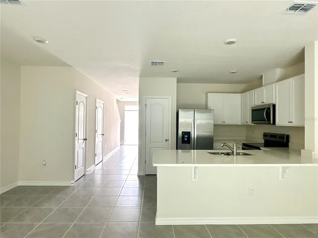 a view of a kitchen with kitchen island and stainless steel appliances