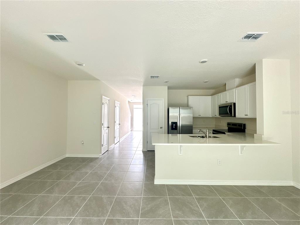 2742 Puffin Place Davenport, FL 33837 - Photo 12 of 31 a view of a kitchen with kitchen island and stainless steel appliances