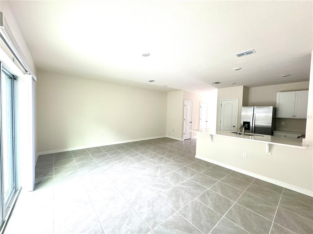 2742 Puffin Place Davenport, FL 33837 - Photo 15 of 31 a view of a kitchen with kitchen island a sink wooden floor and a counter top space