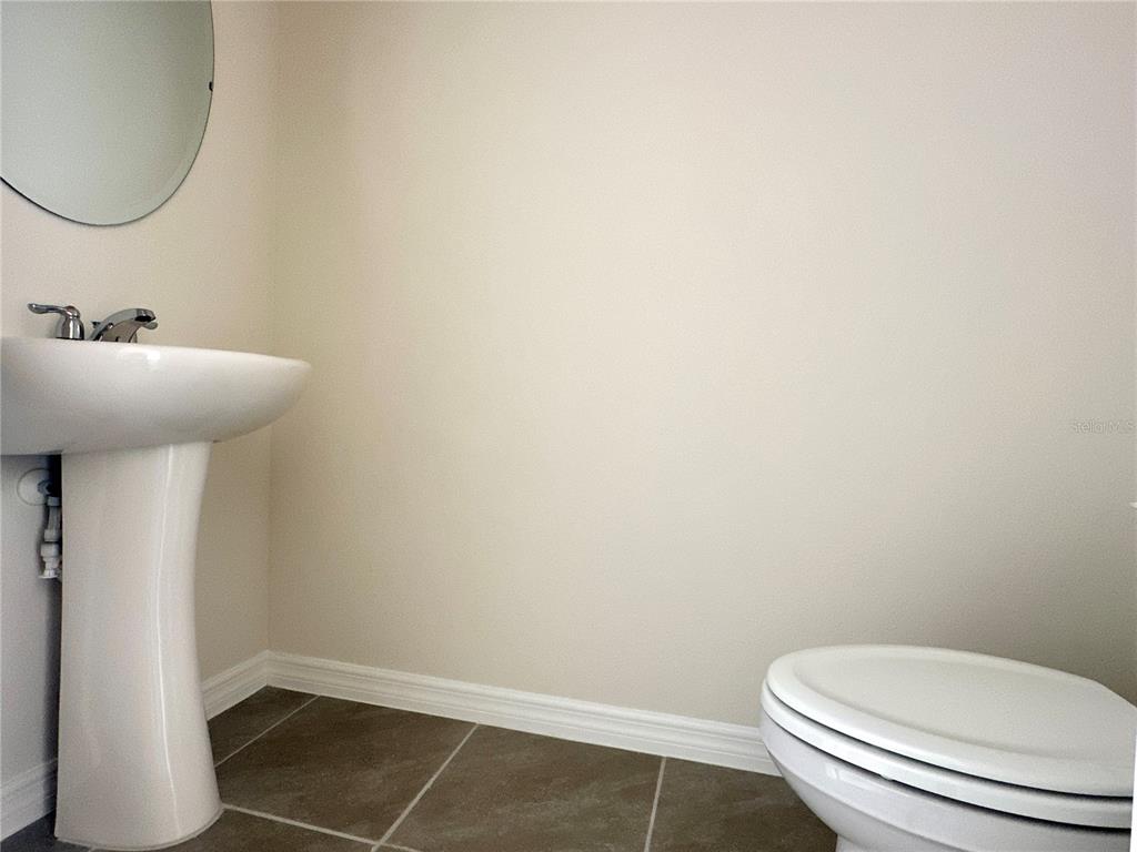 2742 Puffin Place Davenport, FL 33837 - Photo 16 of 31 a bathroom with a toilet sink and mirror